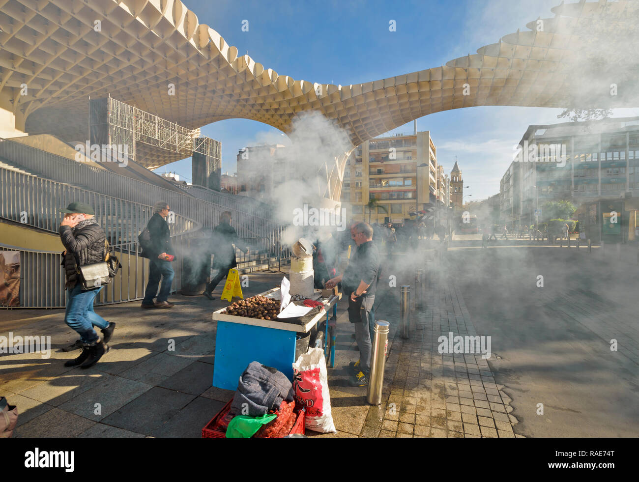 METROPOL PARASOL ENCARNACION SQUARE  SEVILLE SPAIN EARLY MORNING CLOUDS OF SMOKE FROM ROAST CHESTNUT SELLER Stock Photo