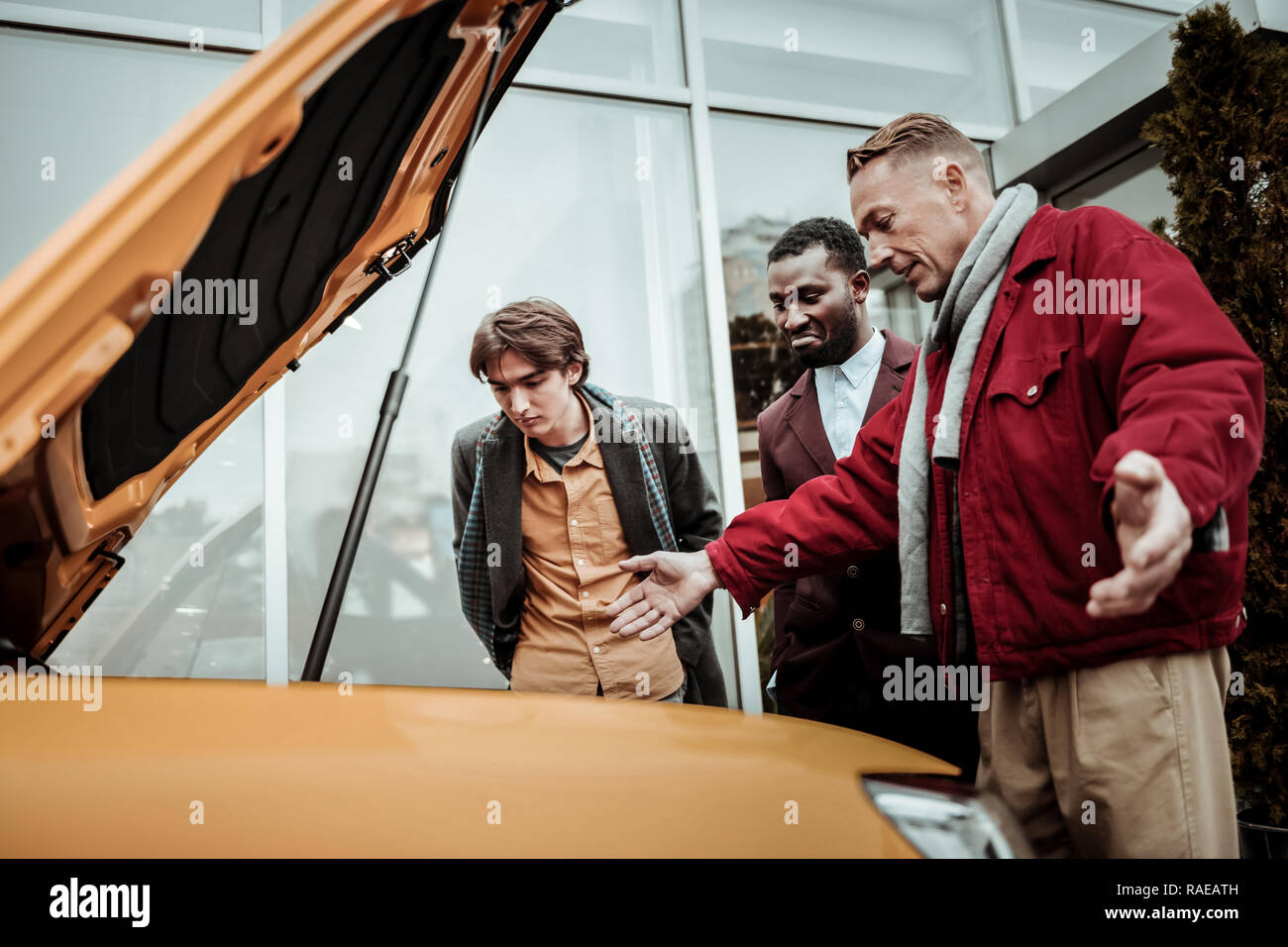 Young dark-haired son feeling excited before driving his first car Stock Photo