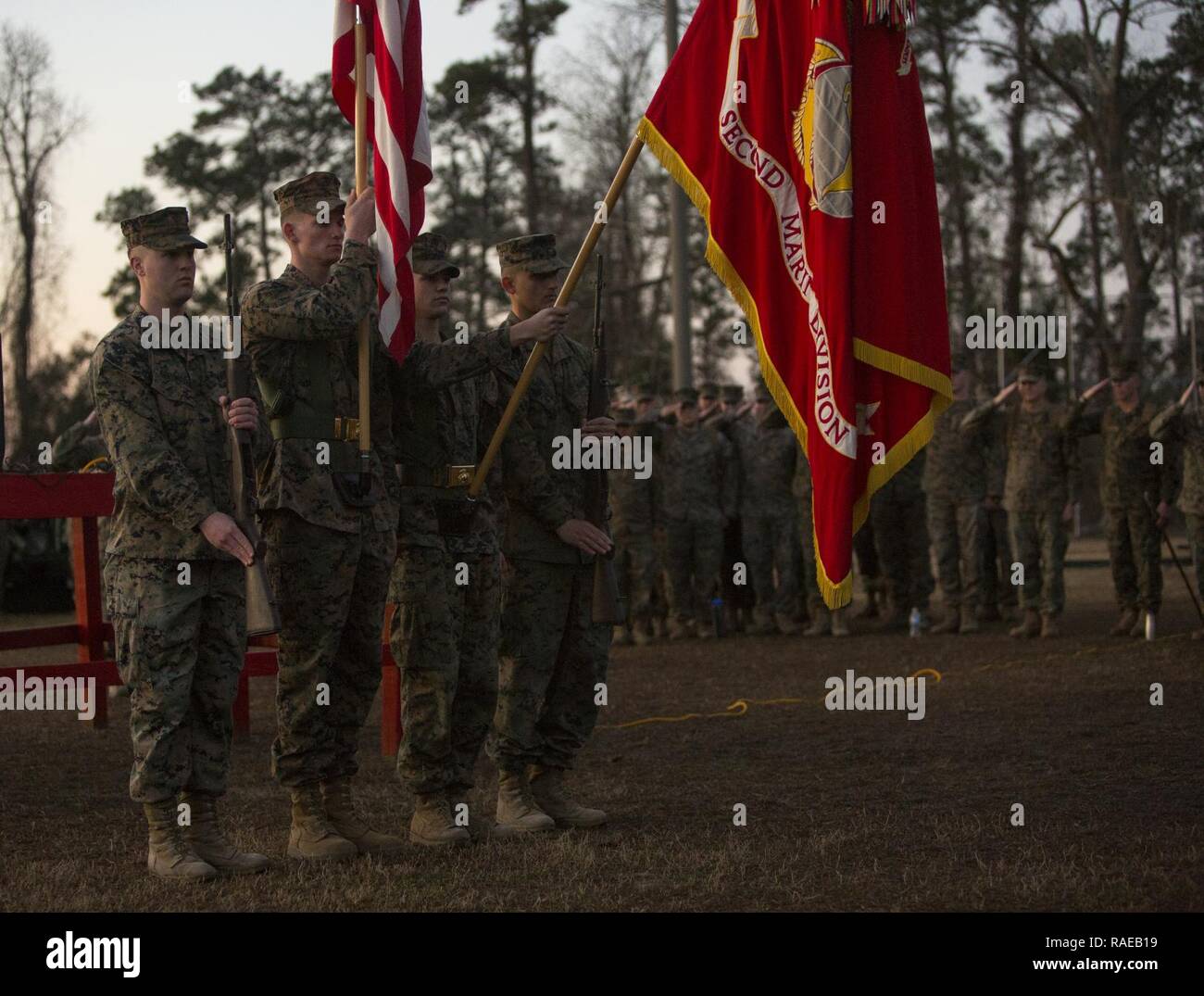 U.S. Marines with the 2nd Marine Division (2d MARDIV) color guard, deliver the battle colors before the 2d MARDIV 50-mile challenge hike on Camp Lejeune, N.C., Feb. 1, 2017. The hike was held to challenge Marines of 2d MARDIV as well as test their skill and will. Stock Photo