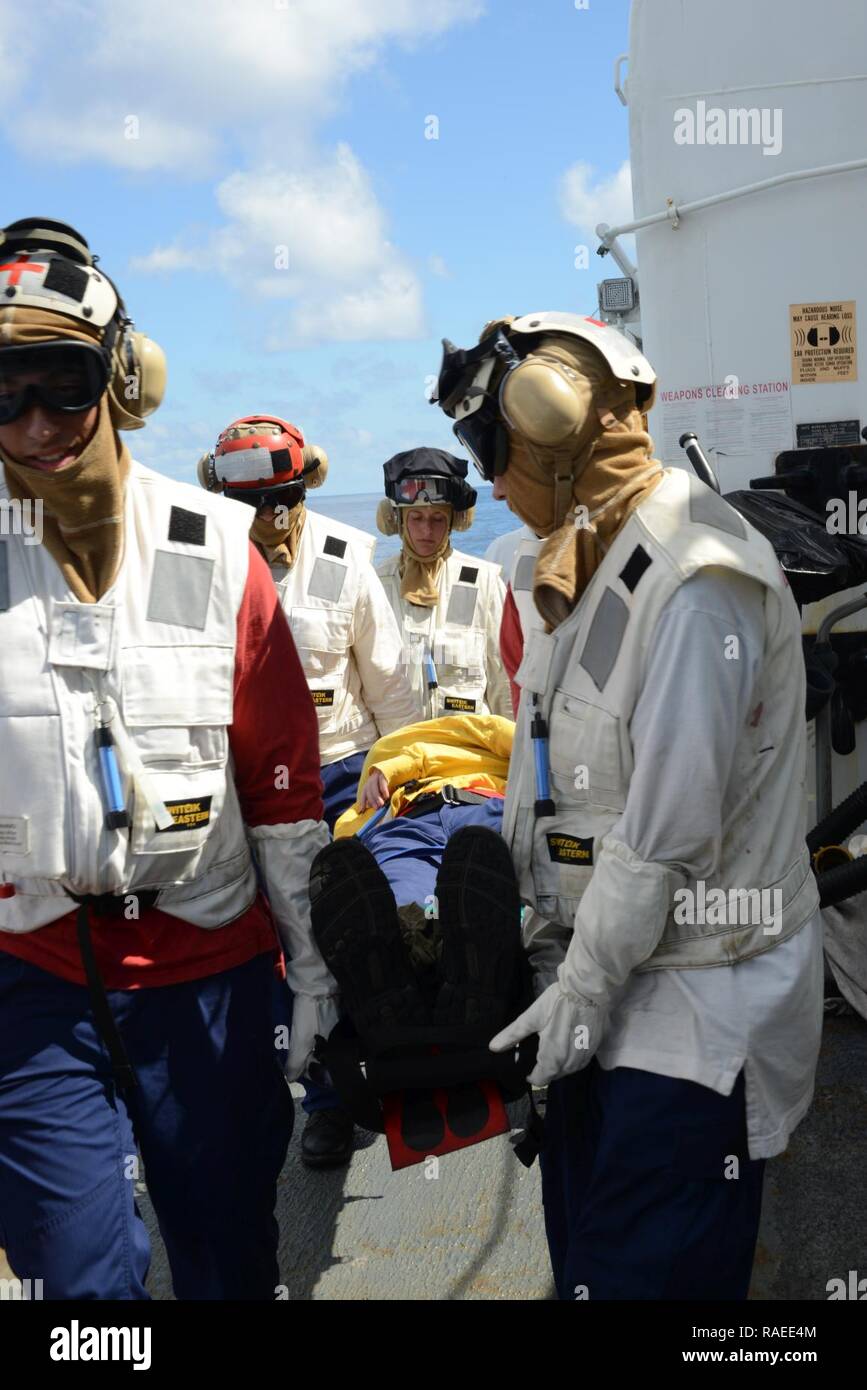 EASTERN PACIFIC OCEAN – Seaman Kristine Kearny (center), a crewmember aboard the Coast Guard Cutter Sherman, leads the responding medical team and assesses the Line Safety Officer on Sherman’s flight deck during a helicopter-crash-on-deck drill, Jan. 19, 2017. The crew of Sherman is currently deployed in support of counter drug operations. Cutters like Sherman routinely conduct operations from South America to the Bering Sea conducting alien migrant interdiction operations, domestic fisheries protection, search and rescue, counter-narcotics and other Coast Guard missions at great distances fro Stock Photo