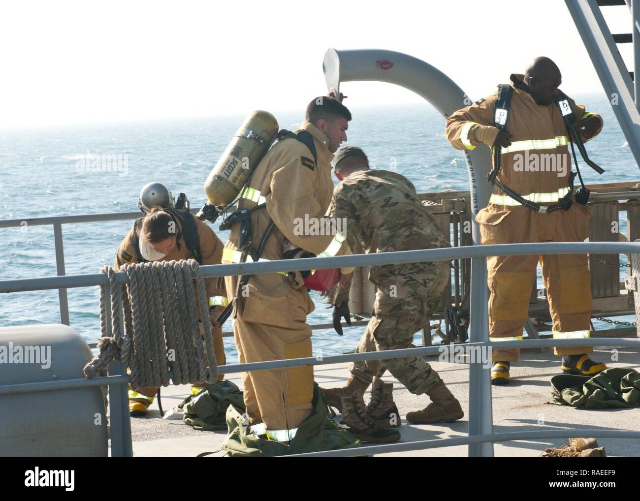 U.S. Army mariners, of the 411th Transportation Company, don firefighting gear during a fire drill aboard Logistics Support Vessel - 5 (LSV-5)on January 24, 2017. Fire drills are one of three drills that are required by federal regulation to be conducted weekly aboard Army watercraft. Stock Photo
