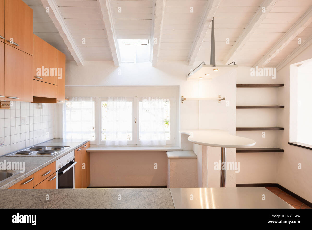 Front view of vintage kitchen with wooden furniture. On the ceiling white wooden beams Stock Photo