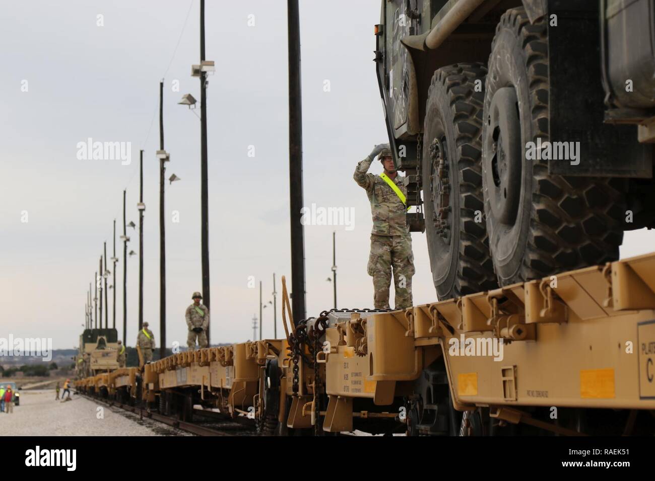Sgt. Brice Lawrence, 303rd Military Intelligence Battalion, 504th Military Intelligence Brigade, guides a vehicle through the rail, Dec. 12, 2018, Fort Hood, Texas. Soldiers worked with other units to load all vehicles for movement. Stock Photo