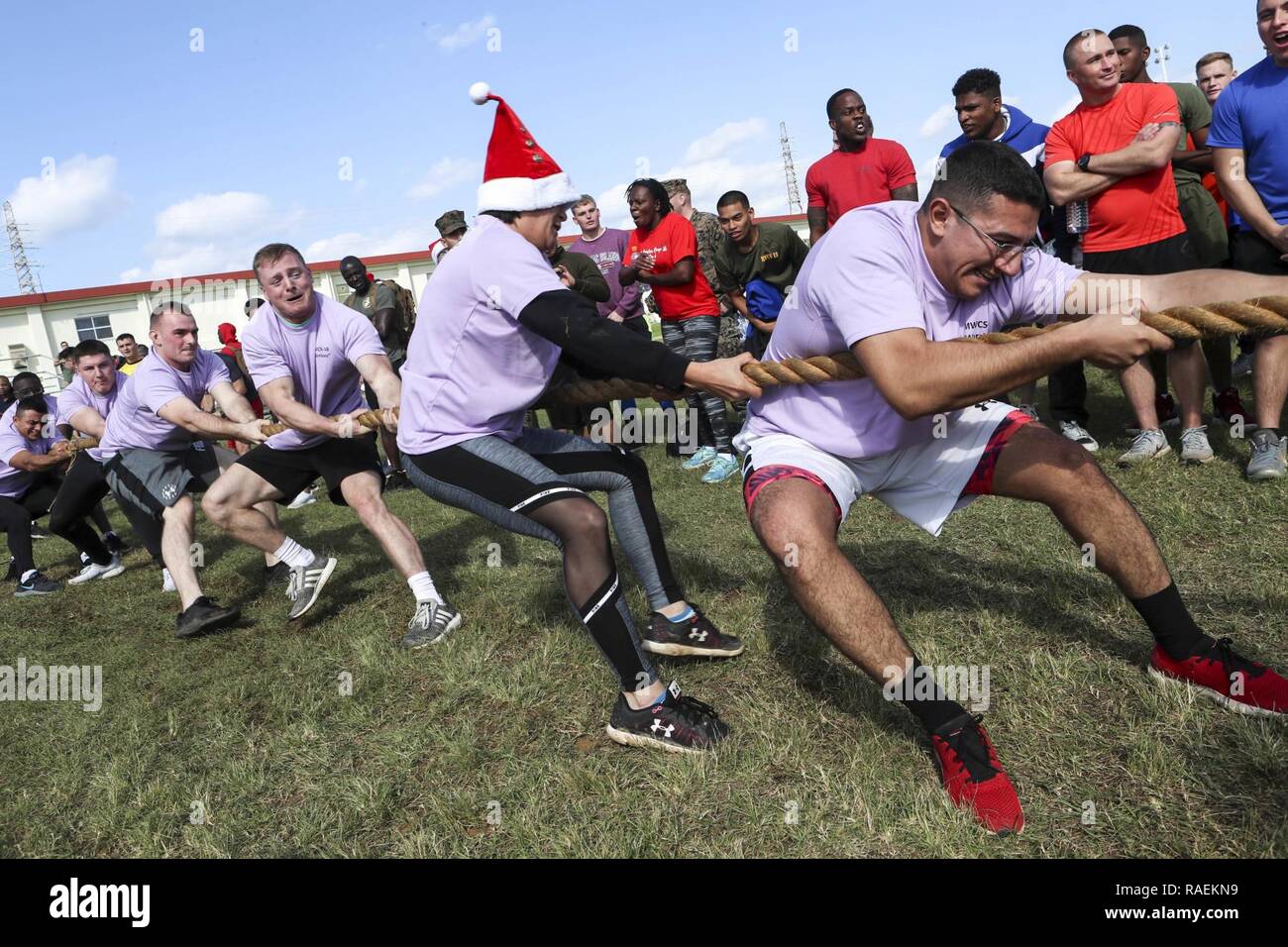 U.S. Marines assigned to Marine Tactical Air Command Squadron 18, 1st Marine Aircraft Wing, participate in tug-of-war during the Jingle Bell Challenge on Camp Foster, Okinawa, Japan, Dec. 14, 2018. The challenge was held to promote cohesion between Navy and Marine Corps units aboard MCB Camp Butler by participating in various competitions like tire flipping, a five kilometer run, and ammunition can lifts. Stock Photo