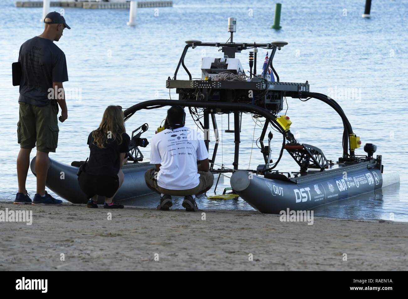 HONOLULU, Hawaii (Dec. 14, 2018) Judges and staff check the operation Queensland University of Technology's underwater vehicle, attached to their autonomous surface vehicle, during the next to last day of competition at the Office of Naval Research (ONR)-sponsored Maritime RobotX Challenge in Honolulu, Hawaii. Organized by RoboNation and Navatek, RobotX is designed to foster student interest in autonomous robotic systems operating in the maritime domain, with an emphasis on the science and engineering of cooperative autonomy. Stock Photo