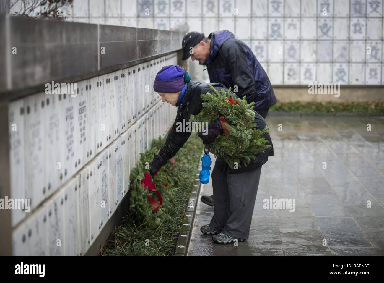 Volunteers lay wreaths in Columbarium Court 6 during the 27th National Wreaths Across America Day at Arlington National Cemetery, Arlington, Virginia, Dec. 15, 2018. On this day, thousands of volunteers place wreaths at every gravesite at Arlington National Cemetery. Stock Photo