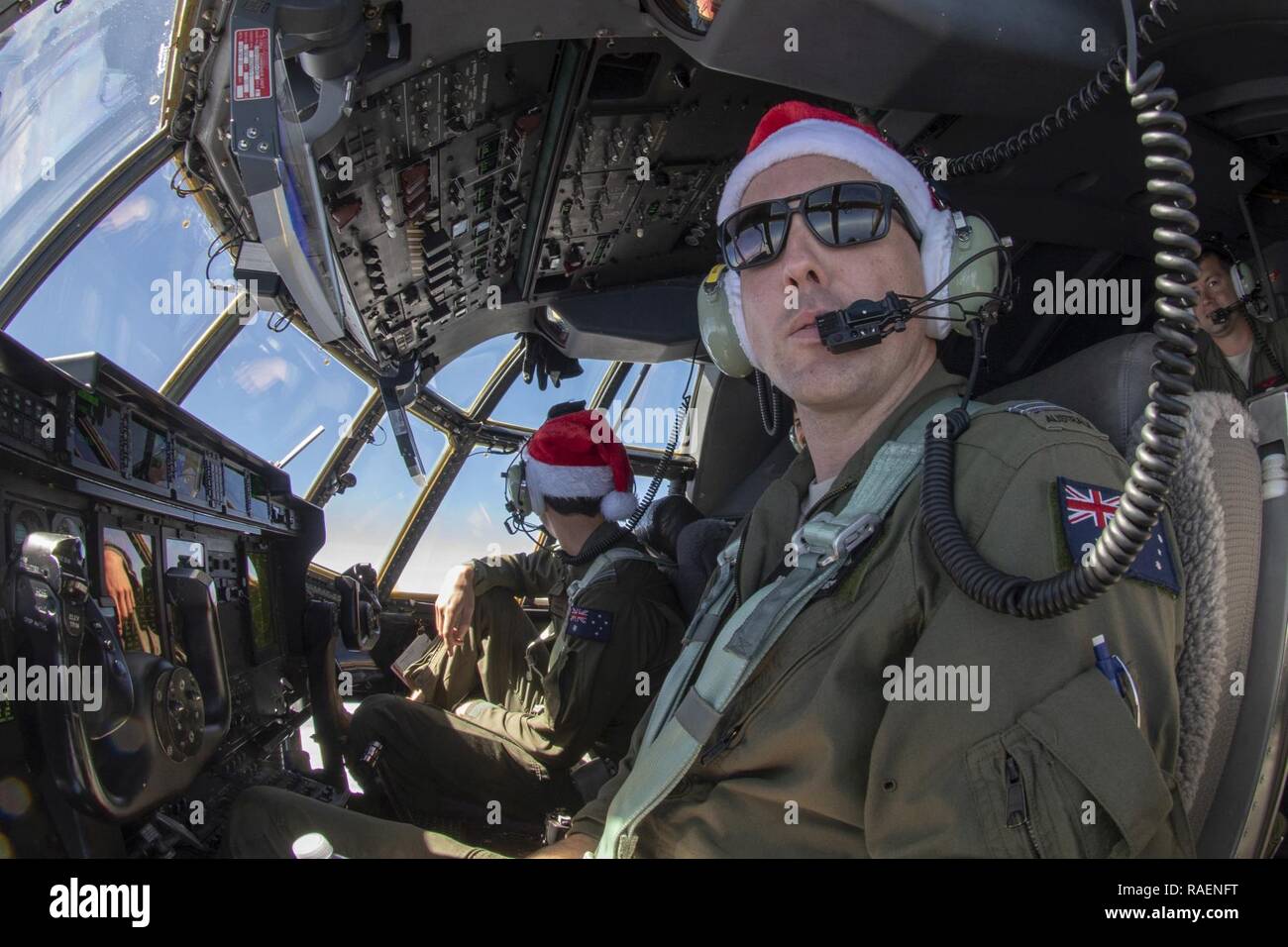 Royal Australian Air Force FLTLT Simon Mason, 37th Squadron C-130J Super Hercules pilot out of RAAF Base Richmond, Australia, looks out at the horizon on Santa 99’s way to the atoll of Kapingamarangi, Federated States of Micronesia, during Operation Christmas Drop 2018, Dec. 13, 2018. Starting with the first airdrop to Kapingamarangi 67 years ago, OCD is the world’s longest running airdrop training mission, providing critical supplies to 56 Micronesian islands and impacting approximately 20,000 people across 1.8 million square nautical miles of operating area. Stock Photo