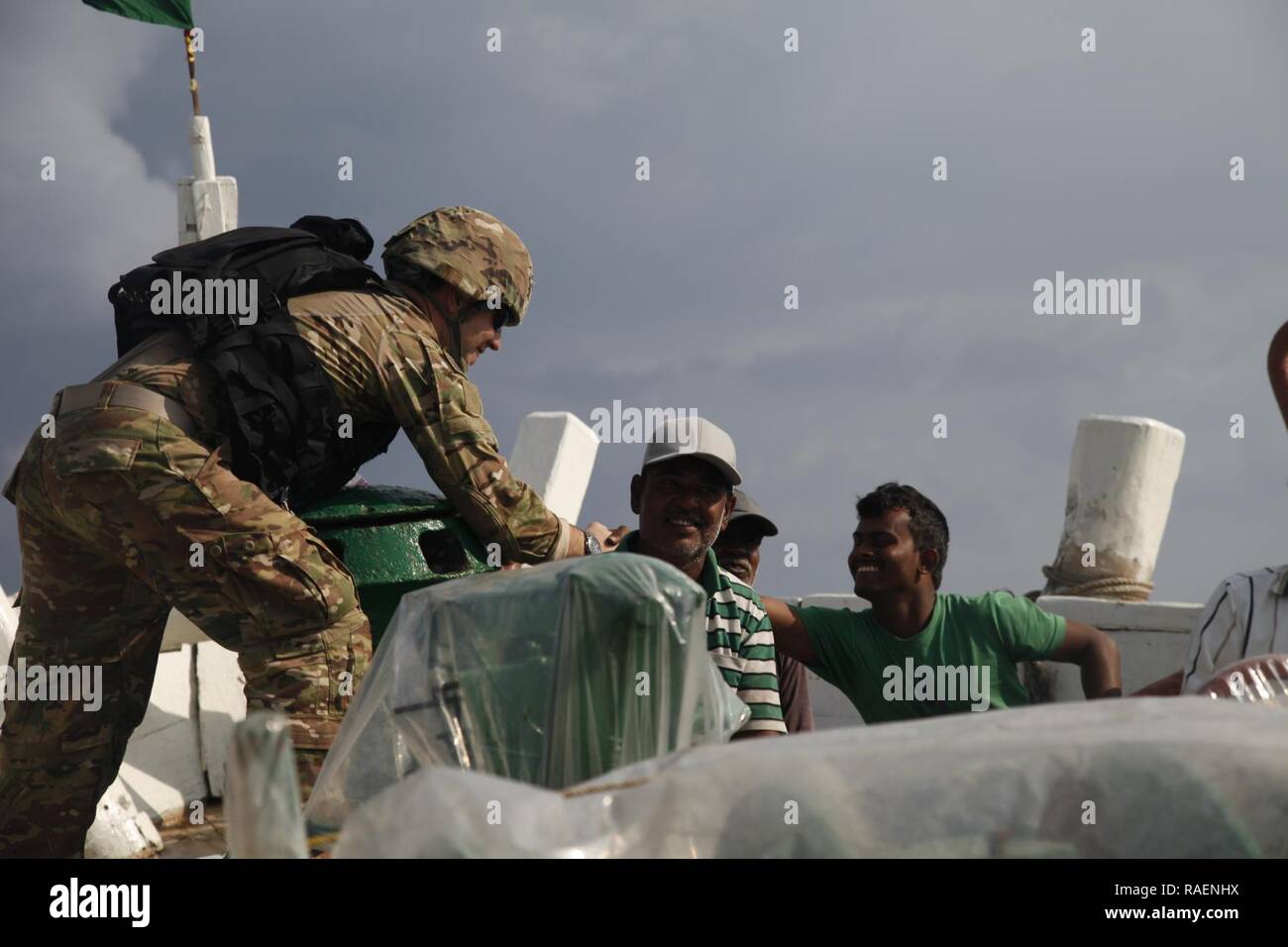 GULF OF OMAN (Dec. 15, 2018) U.S. Army Sgt. Gavin Wilson hands out supplies from the Cyclone-class coastal patrol ship USS Thunderbolt (PC 12) to dhow crewmembers.  Thunderbolt is deployed to the U.S. 5th Fleet area of operations in support of naval operations to ensure maritime stability and security in the Central Region, connecting the Mediterranean and the Pacific through the western Indian Ocean and three strategic choke points. Stock Photo
