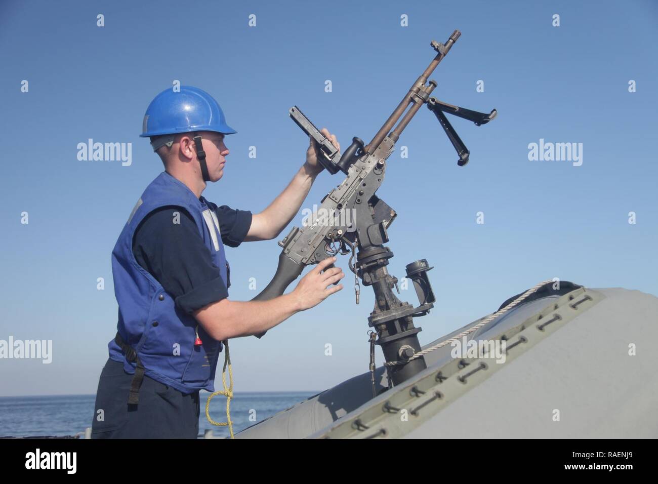 GULF OF OMAN (Dec. 13, 2018) A U.S. Navy Sailor performs a safety check on an M240B machine gun aboard the Cyclone-class coastal patrol ship USS Thunderbolt (PC 12)  in the Gulf of Oman. Thunderbolt is deployed to the U.S. 5th Fleet area of operations in support of naval operations to ensure maritime stability and security in the Central Region, connecting the Mediterranean and the Pacific through the western Indian Ocean and three strategic choke points. Stock Photo