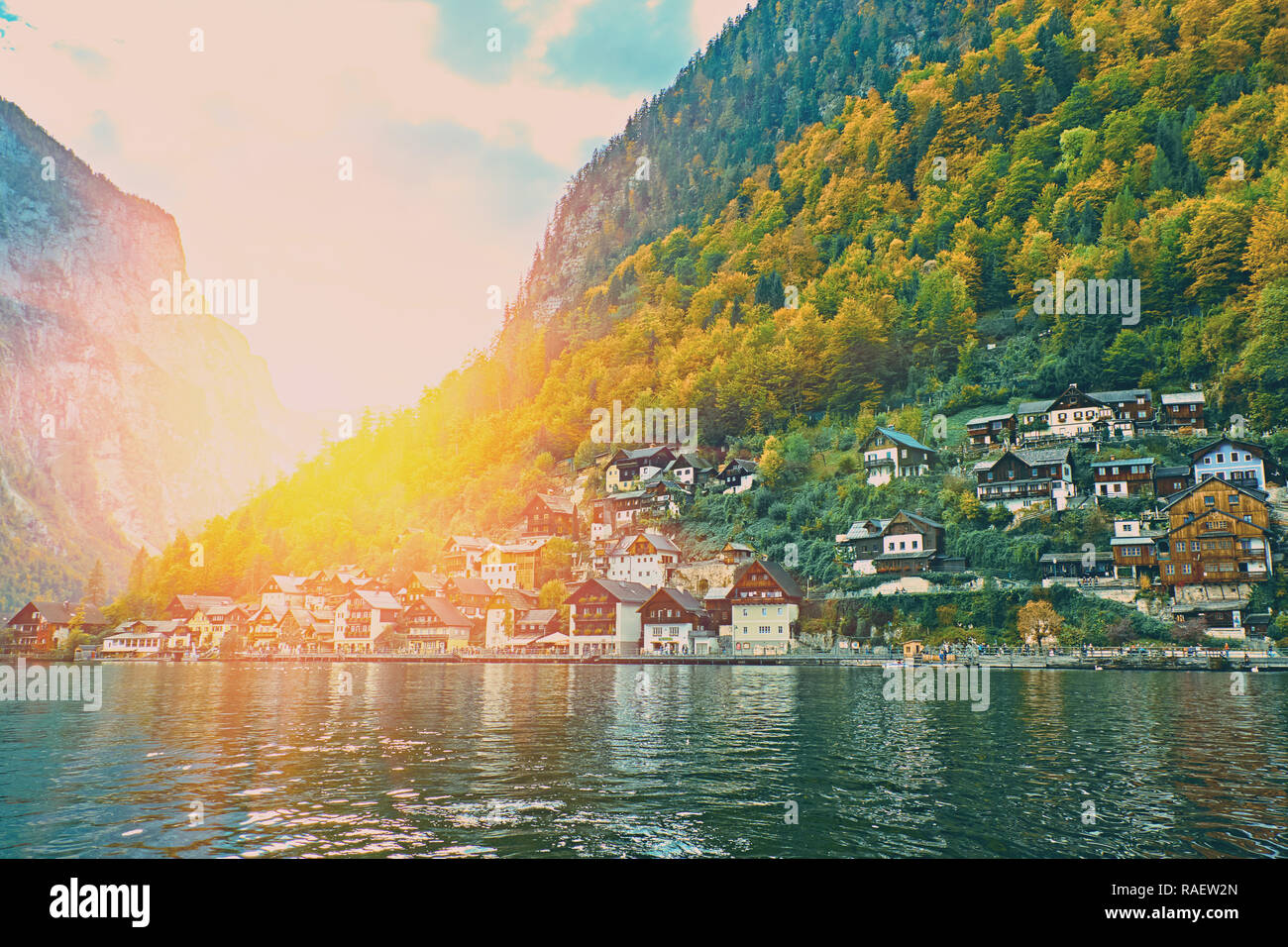 Sunset over Hallstatt austrian alps resort and mountain village with traditional rural alps houses, restaurants, hotels and wooden boat houses at Hall Stock Photo