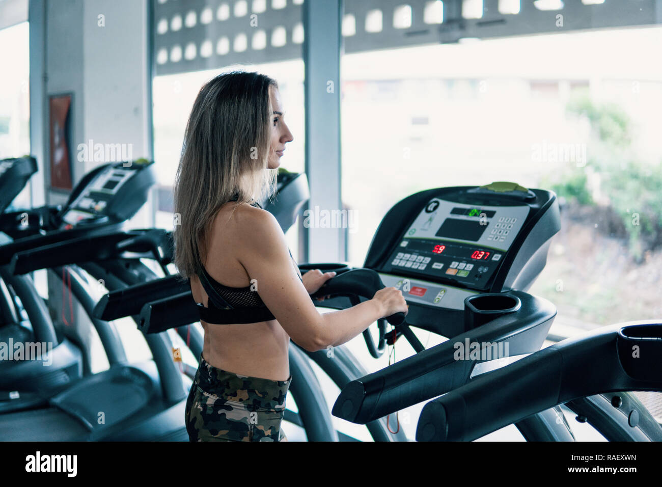 Young fit woman doing running exercise in gym Stock Photo