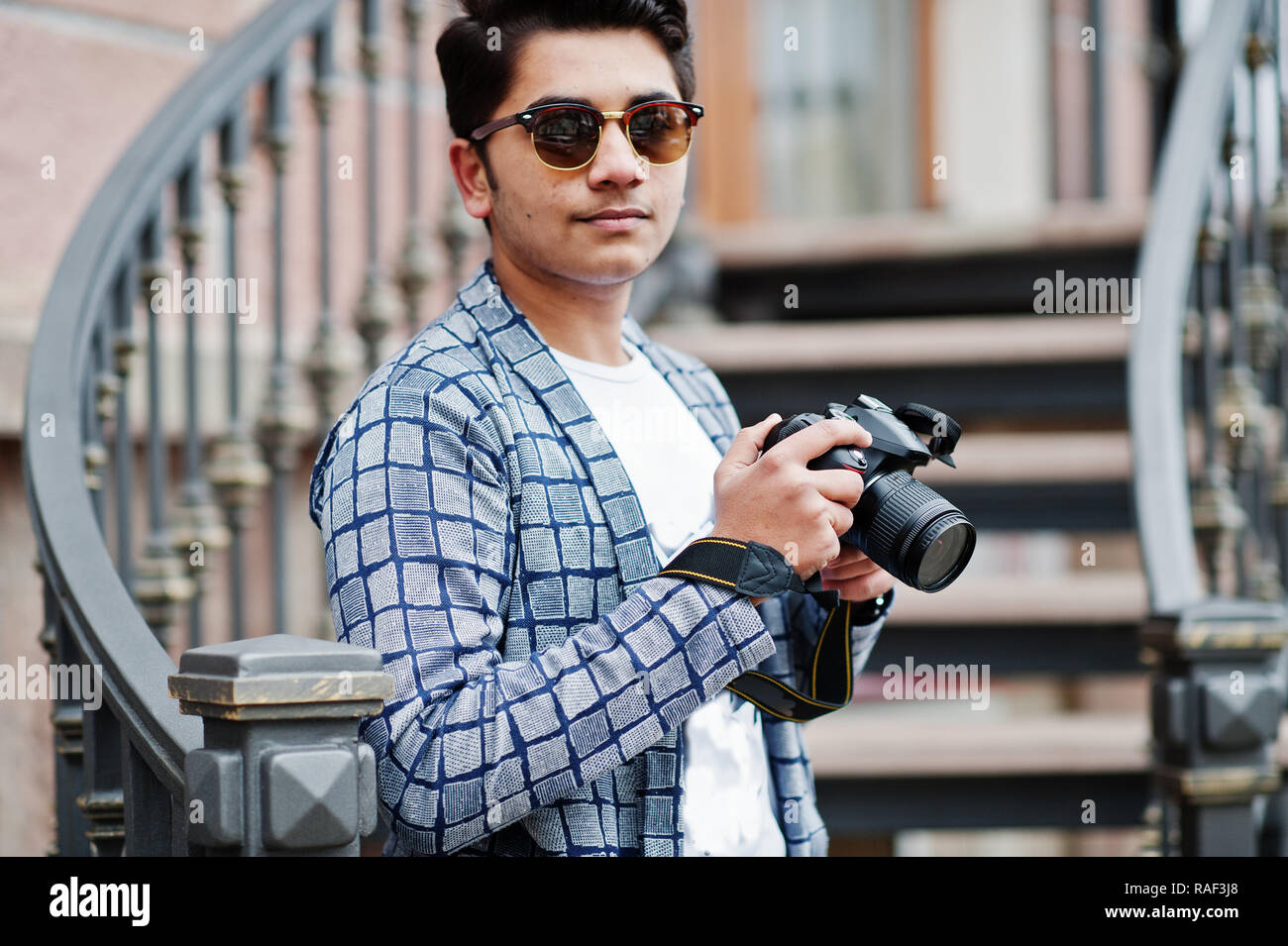 Stylish indian young man photographer at sunglasses wear casual posed  outdoor against iron stairs with dslr photo camera at hands Stock Photo -  Alamy