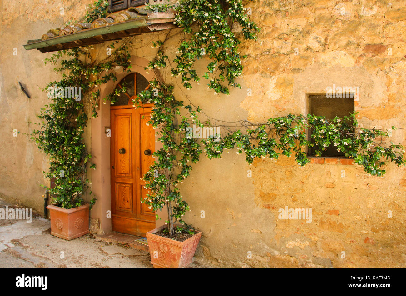 Wall of an old stone house decorated with flowers, Italy Stock Photo ...