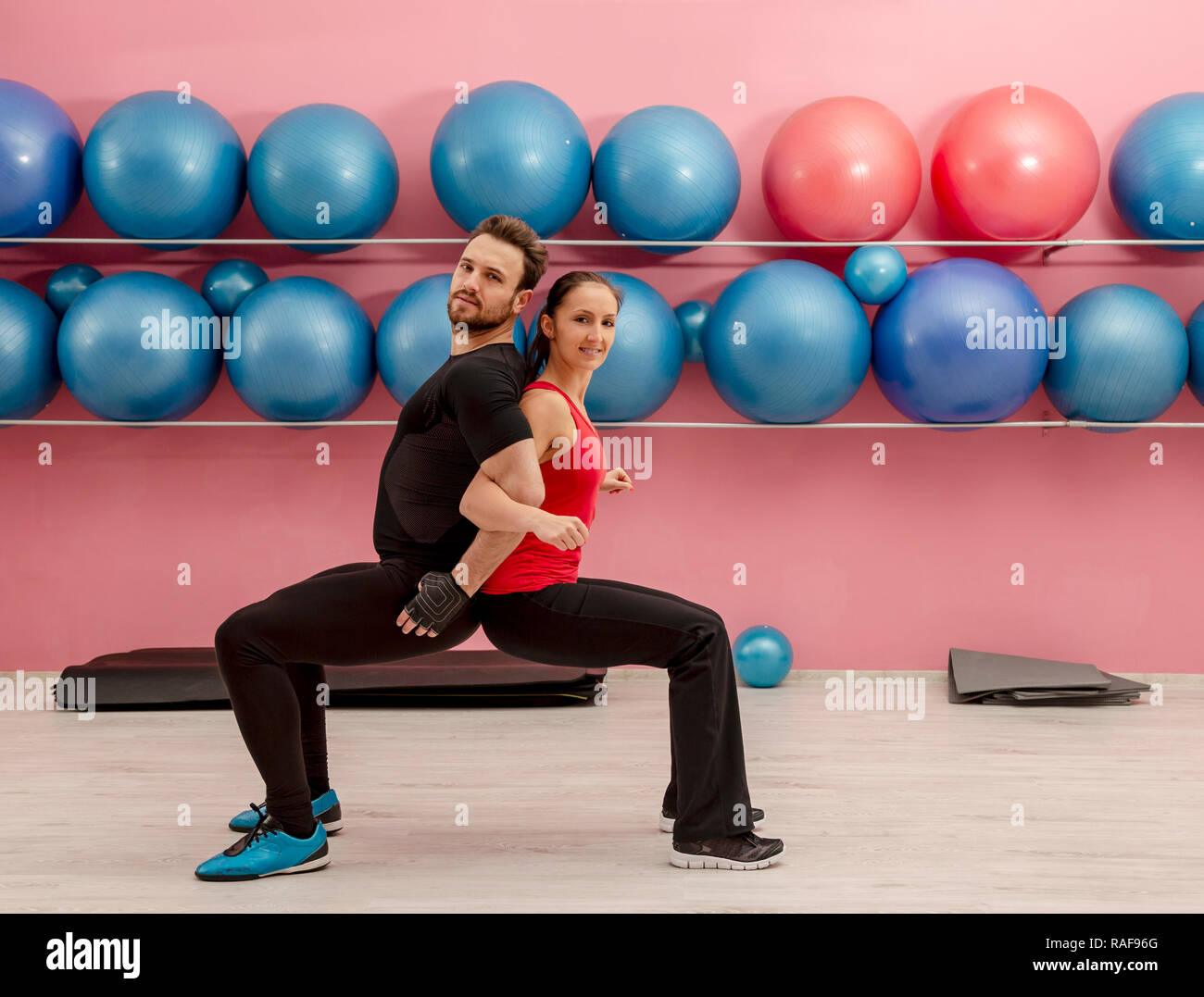 Young couple doing stretching exercises in a gym Stock Photo - Alamy