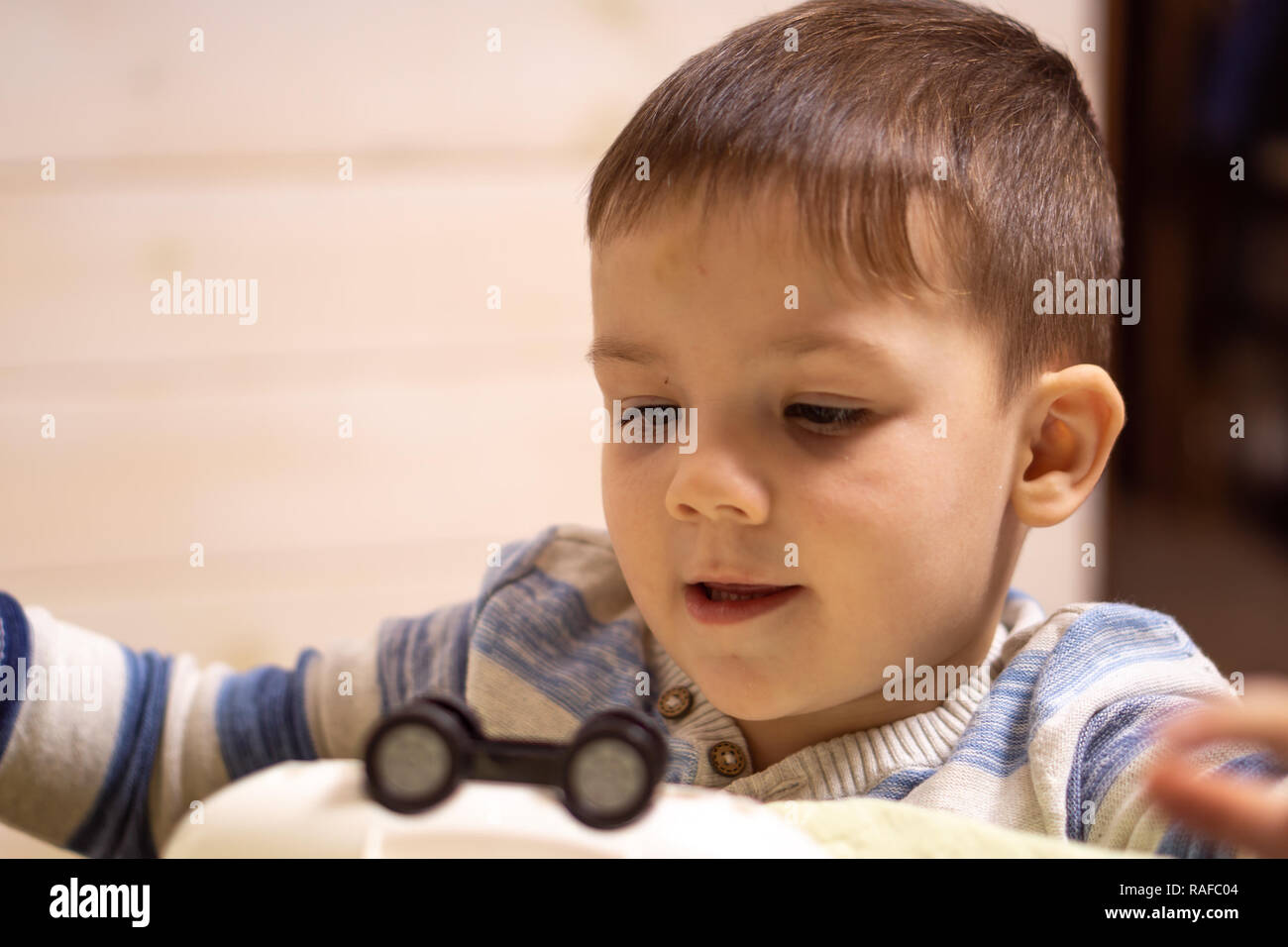 little boy plays with toy car at home Stock Photo - Alamy