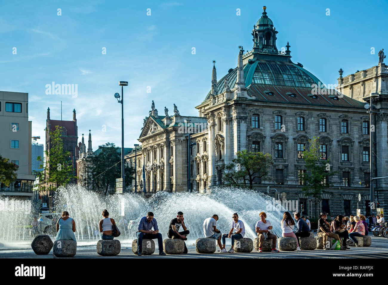 District Court Building and people sitting next to fountain, Munich, Germany Stock Photo