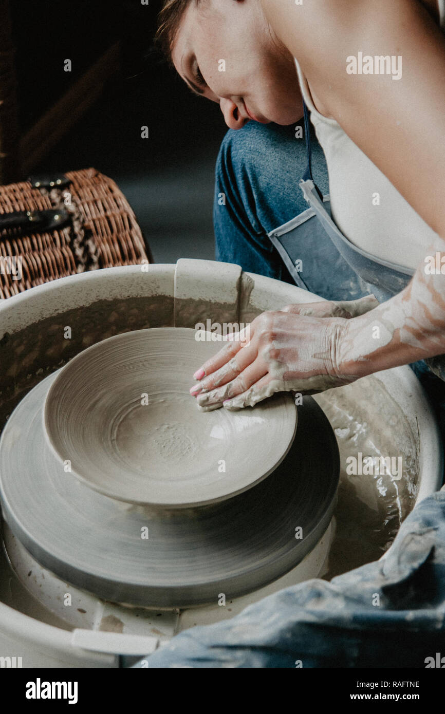 Creating a jar or vase of white clay closeup. Woman hands making clay