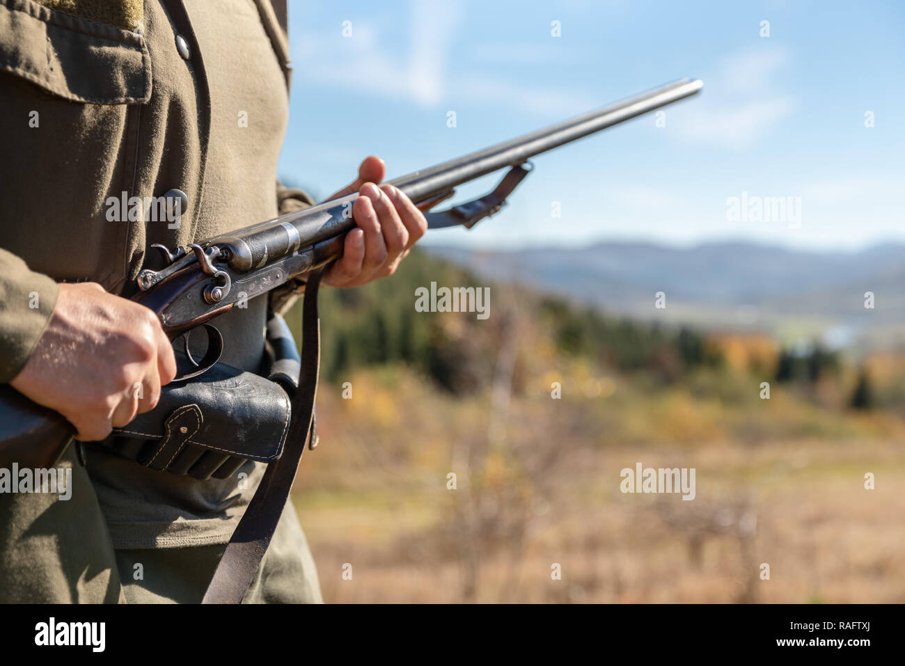 Guard on the environment at work, horizontal double-barreled shotgun in the hands, in the mountains. Stock Photo