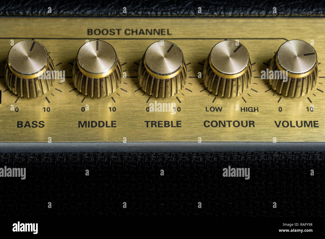 vintage amplifier five knobs horizontal closeup, music recording studio equipment, bottom copy space Stock Photo