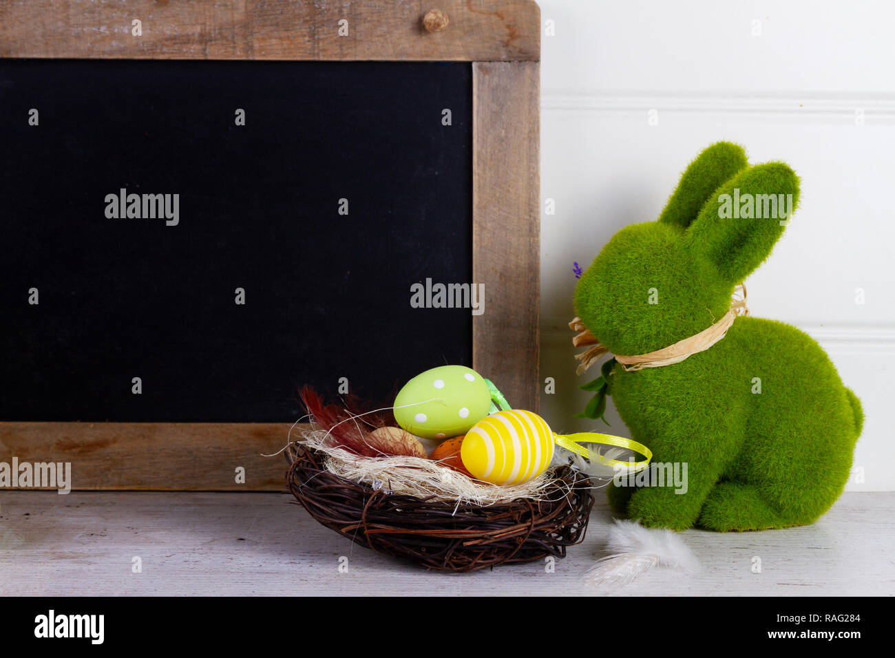 Easter scene with colored eggs in nest and easter green fresh rabbit ...