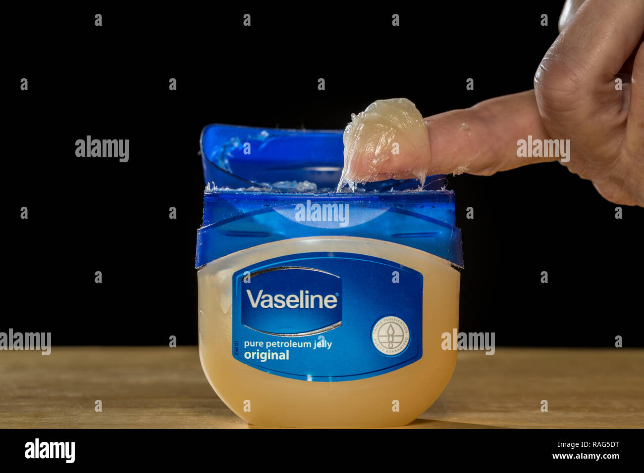 Jar of vaseline petroleum jelly and a lady's finger. Stock Photo