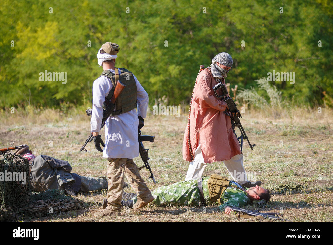 Historical festival Sambek Heights. Mujahideen on the battlefield among dead Soviet soldiers Stock Photo