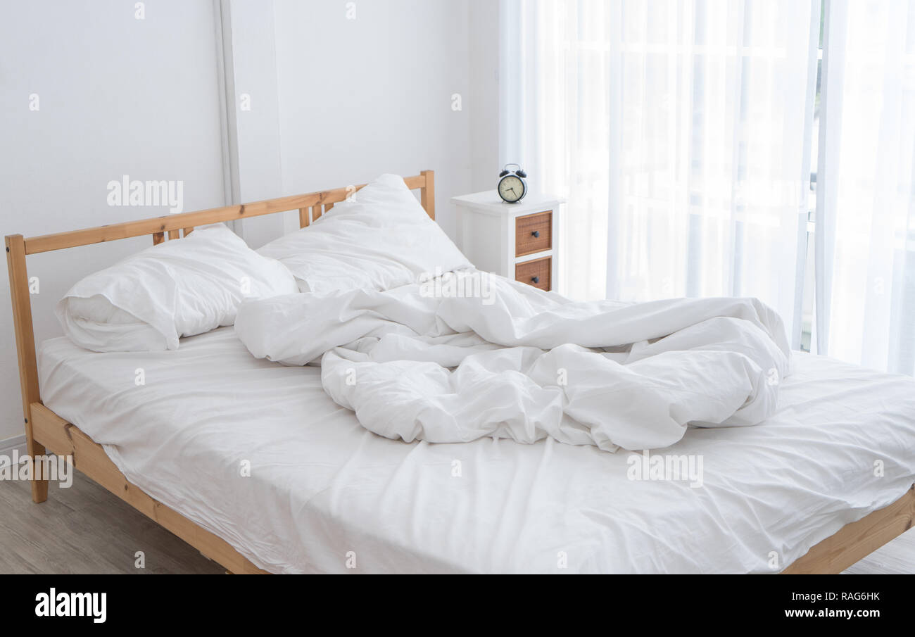 White messy bed in a white room in morning without people Stock Photo ...
