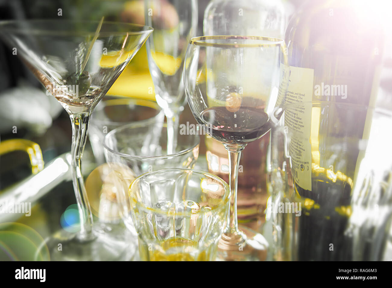 Close up on almost empty alcohol glasses on a tray. End of party, early morning. Stock Photo