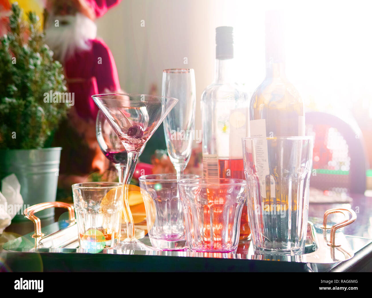 Early morning after the Christmas party, a tray with empty glasses and two bottles. Stock Photo