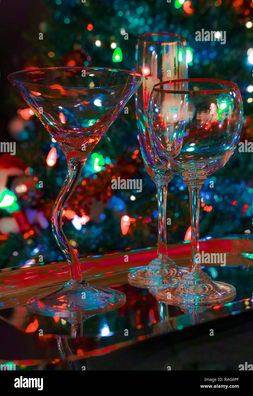 Three different alcohol glasses waiting to be filled. Party ambience and Christmas tree in background. Stock Photo