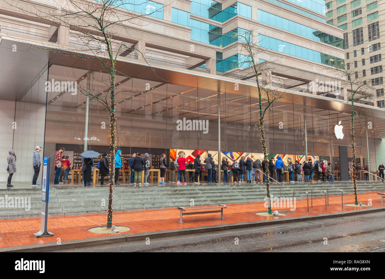 People are embracing the rain to be in line in front of Apple Store in