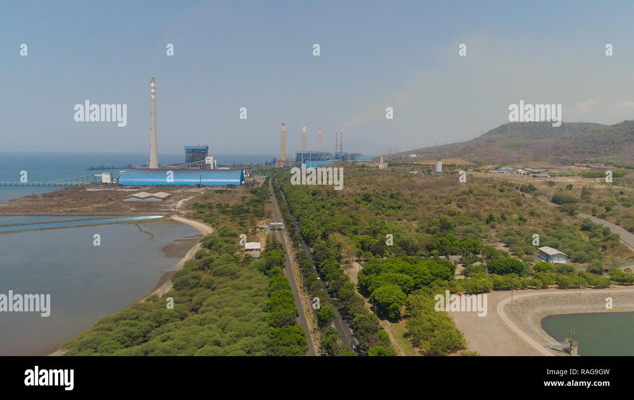 power station by sea with smoking pipes, paiton java, indonesia. aerial view power plant in asia. Stock Photo