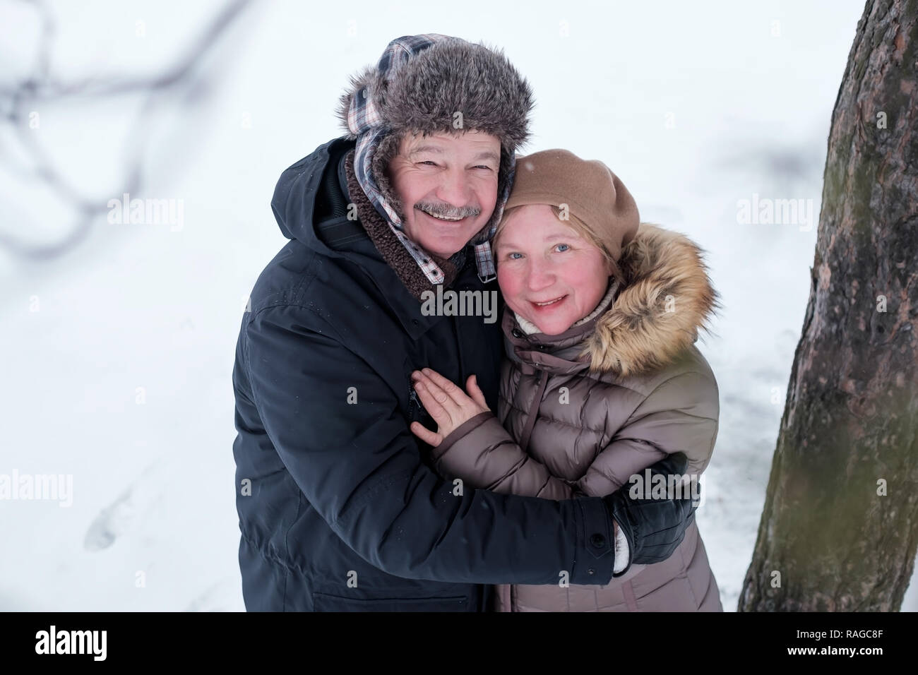 Portrait of elderly couple having fun outdoors in winter forest Stock Photo