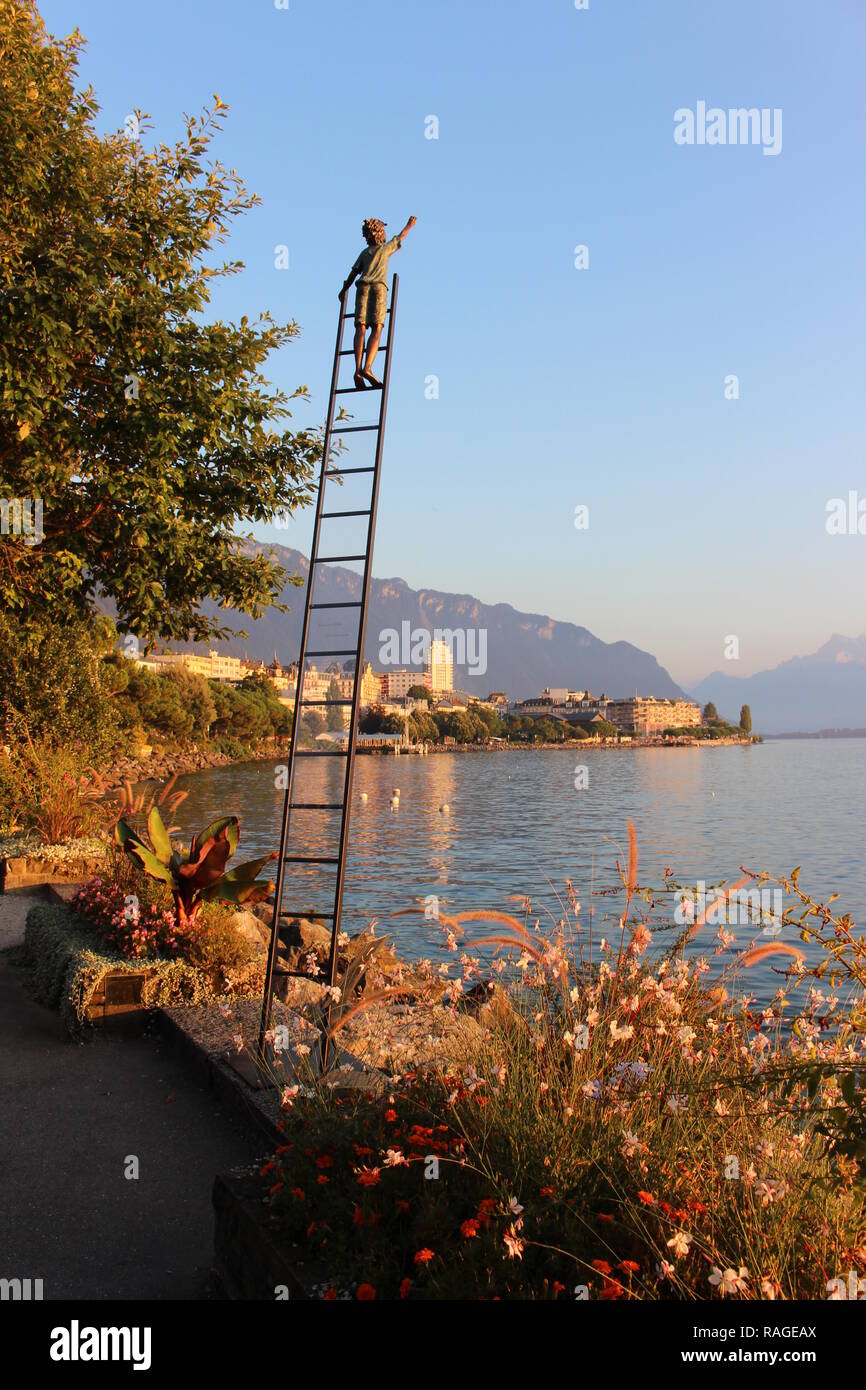 A sculpture of a boy on a ldder, Montreux during sunset, Geneva lake, Switzerland Stock Photo