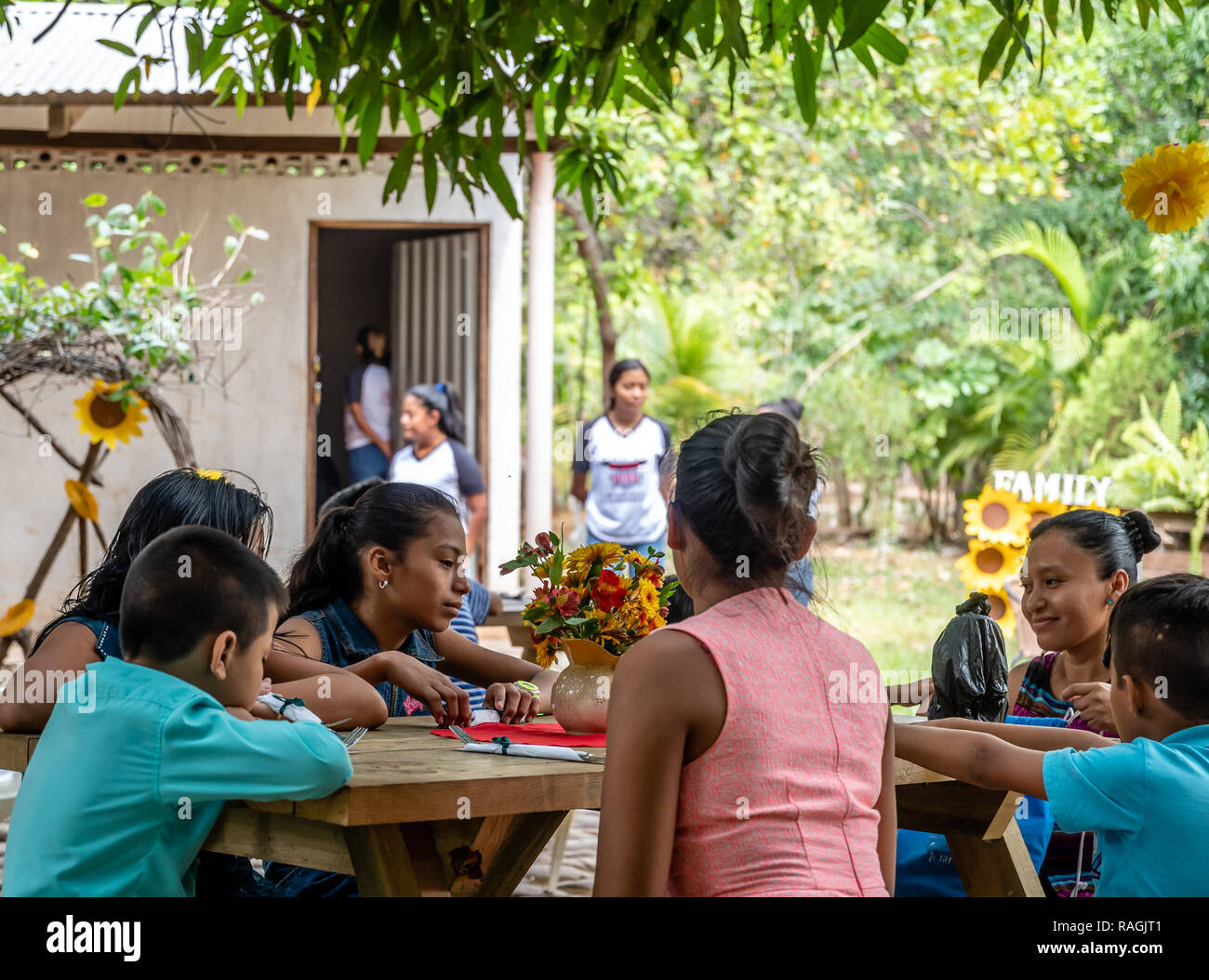 latin youth sitting at picnic table at party in Guatemala Stock Photo