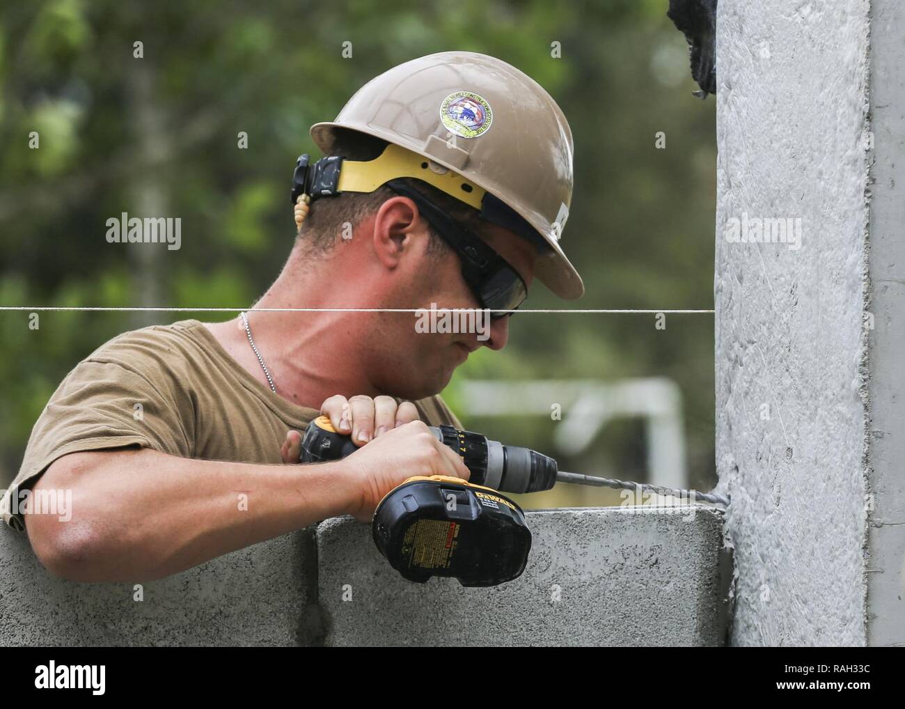 U.S. Navy Seaman Brandon Kase, a builder with Naval Mobile Construction Battalion Five and Chicago native, drills a hole during the construction of a classroom at Ban Nong Muong School, Rayong Province, Thailand, during exercise Cobra Gold, Feb. 2, 2017. Cobra Gold, in its 36th iteration, focuses on humanitarian civic action, community engagement, and medical activities to support the needs and humanitarian interest of civilian populations around the region. Stock Photo