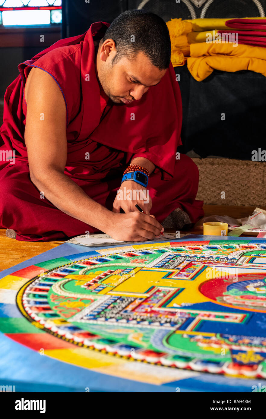 Traveling Tibetan Tashi Kyil Buddhist monks construct a blessed sand Chinrezig Mandala; ceremoniously to be dissolved in the Arkansas River; Salida; C Stock Photo