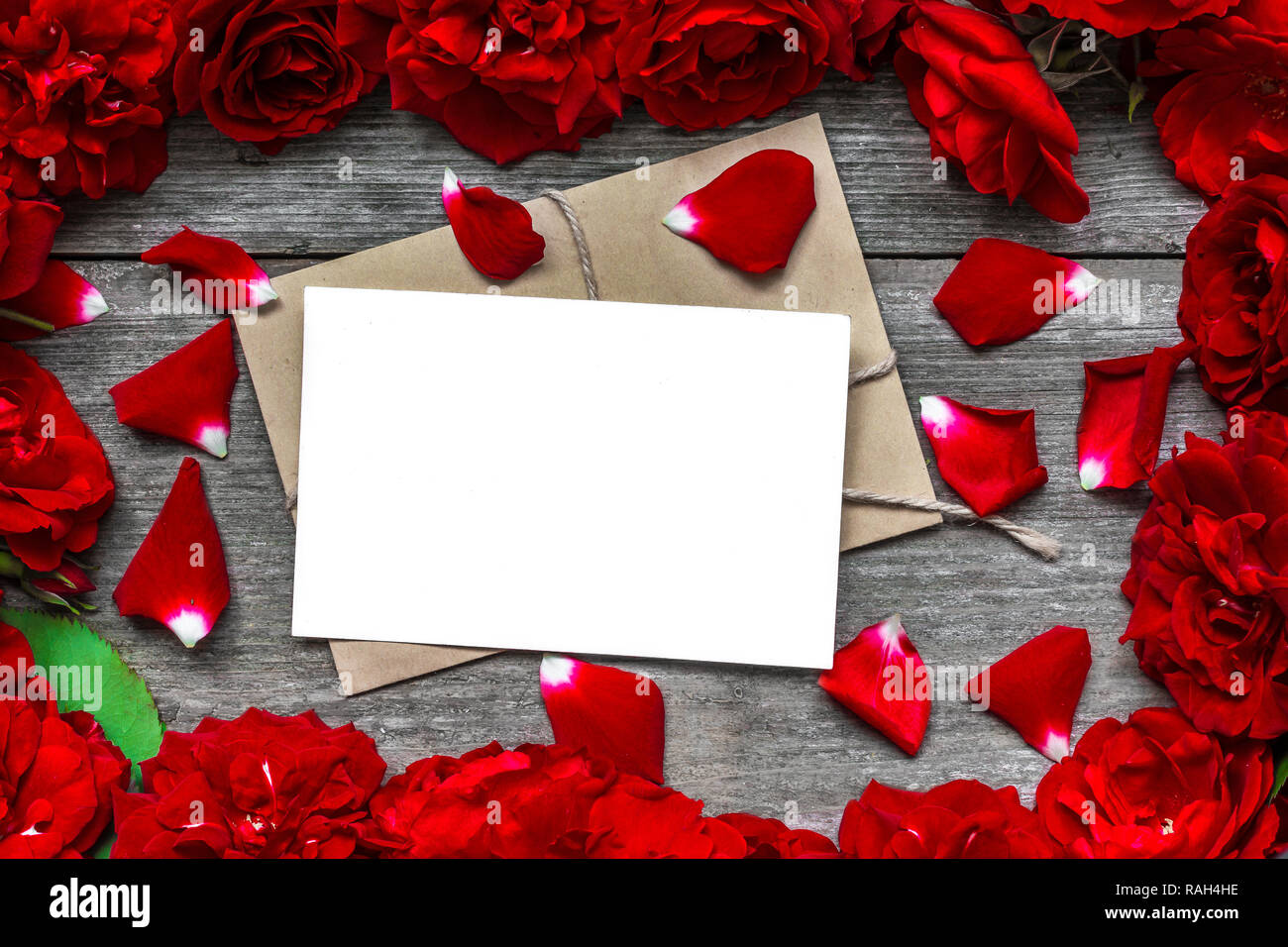 blank greeting card in frame made of red roses flowers and petals. mock ...