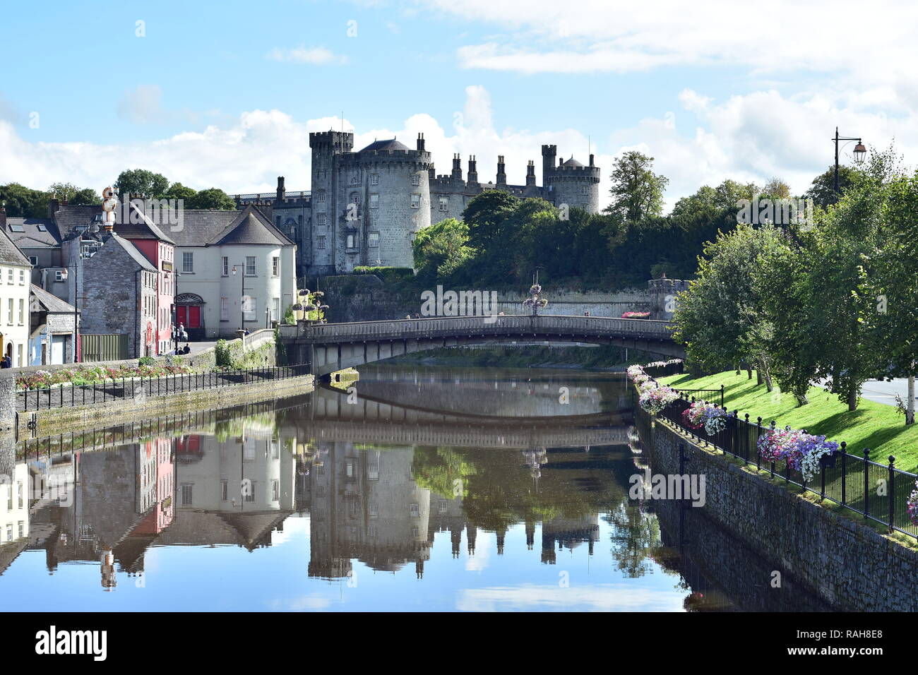 View of calm river Nore with bridge and stone Kilkenny Castle in background. Stock Photo