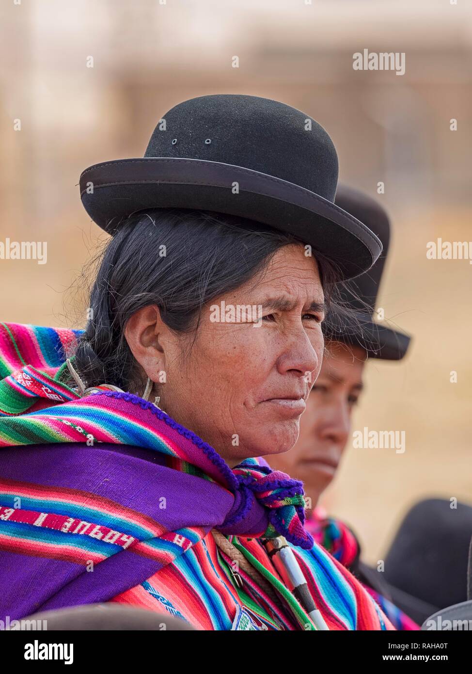 Indigenous women (chola, cholita) in typical national clothing (pollera, overskirt and scarf, manta) with typical hat (melon Stock Photo