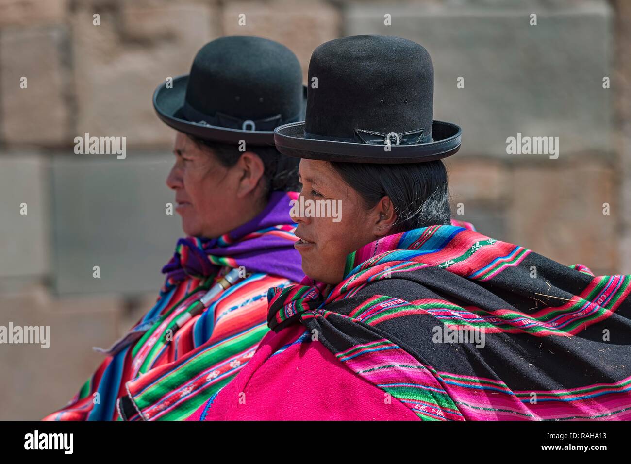 Indigenous women (chola, cholita) in typical national clothing (pollera, overskirt and scarf, manta) with typical hat (melon Stock Photo