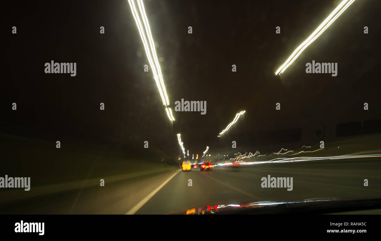 Driving on the M8 Motorway through Glasgow at night taken on a slow exposure camera setting to show the motion blur and speed of the car. Glasgow, UK  Stock Photo