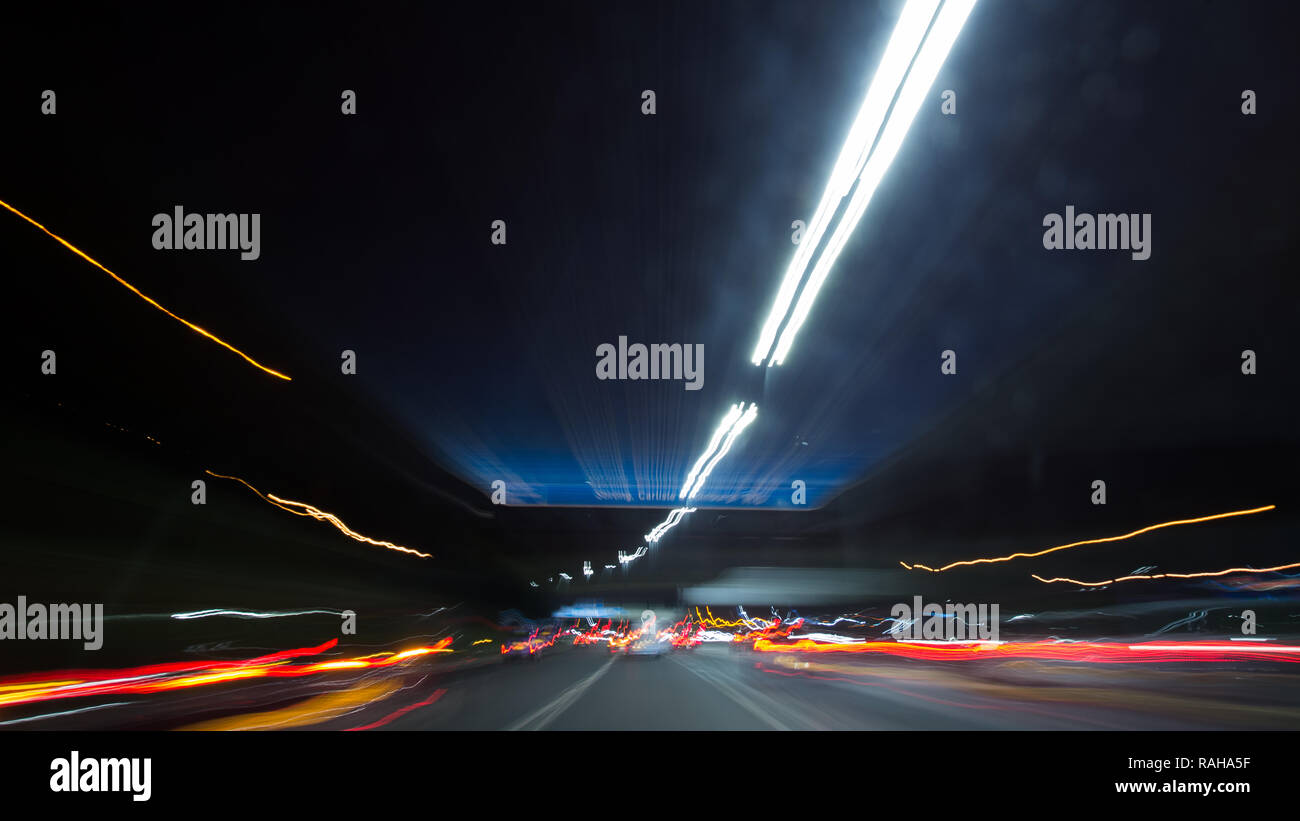 Driving on the M8 Motorway through Glasgow at night taken on a slow exposure camera setting to show the motion blur and speed of the car. Glasgow, UK  Stock Photo