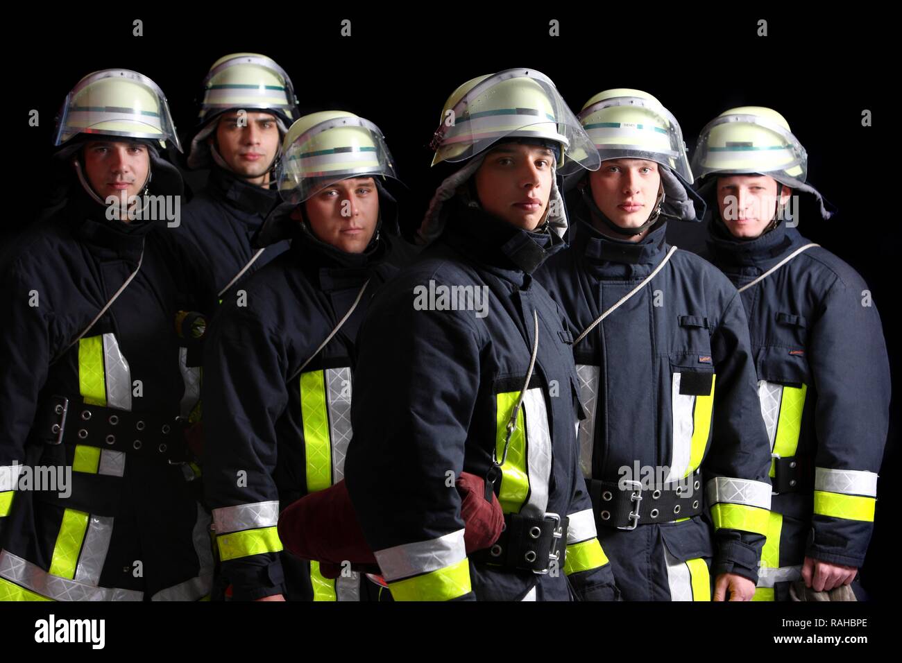 Firefighters wearing their uniforms for a response, protective clothing made of Nomex, a helmet with a visor, professional Stock Photo