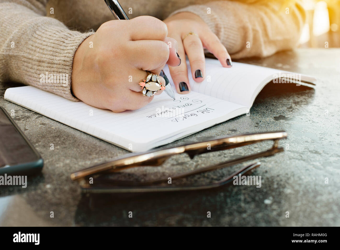 View of female hands writing her life goals in a journal Stock Photo