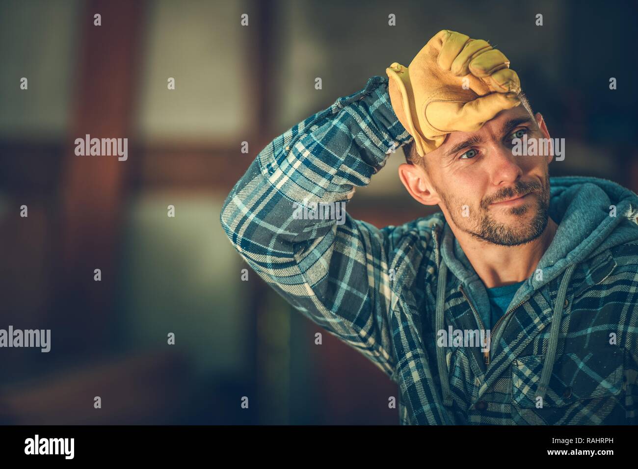 Tired by Happy Caucasian Worker in His 30s. Construction Industry. Stock Photo