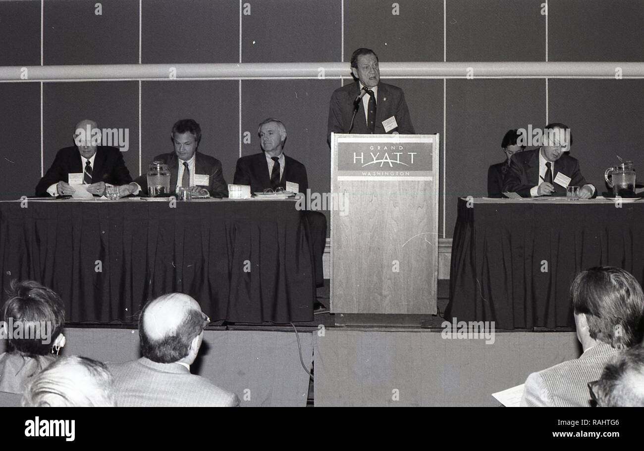 MAN AT THE PODIUM GIVING A SPEECH TO A GROUP OF MEN AND WOMEN Stock ...