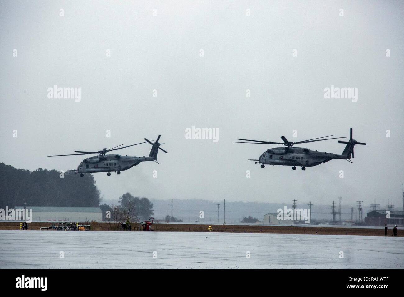 U.S. Marines with Marine Heavy Helicopter Squadron 464 hover CH-53E Super Stallions before another take off during a “Max Launch”, Marine Corps Air Station New River, N.C., Feb. 3, 2017. The purpose for this flight is to celebrate a rarely achieved maintenance goal of having all aircraft operational at one time. Stock Photo