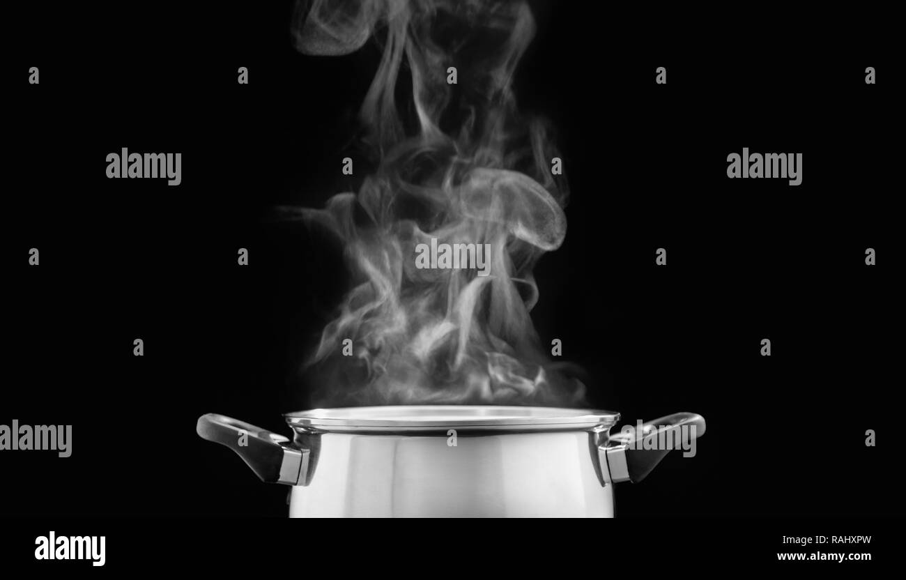 steam over cooking pot in kitchen on dark background Stock Photo