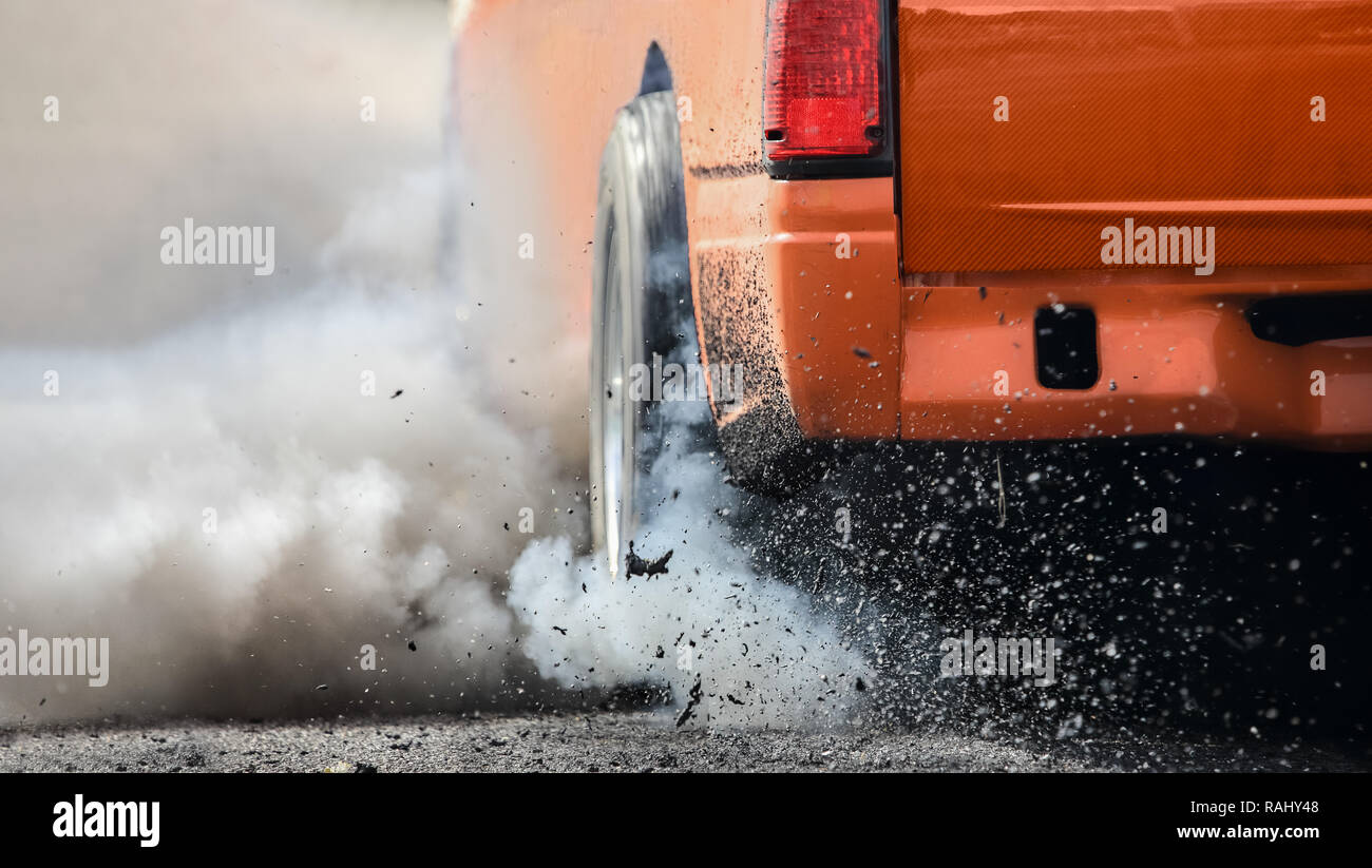 Drag racing car burns rubber off its tires in preparation for the race ...